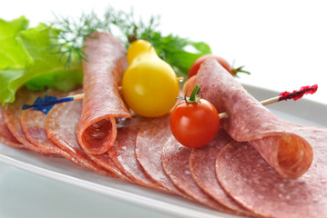 Sliced Salami with tomatoes and salad leaves