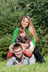 Fototapeta premium Happy parents and daughters in park