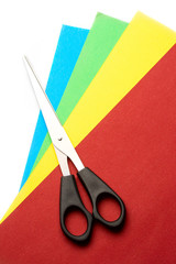 Colored paper and scissors isolated on white