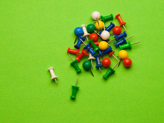 Push pins isolated on green