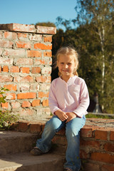 Beautiful girl sitting on a brick stairs