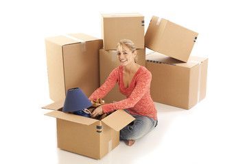 Young woman unpacking cardboard boxes