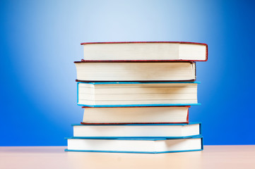 Stack of text books against gradient background