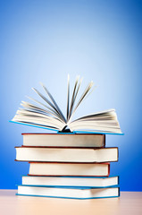 Stack of text books against gradient background