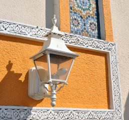 A white streetlamp on a Moroccan style wall