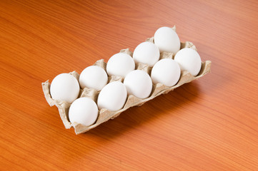 Many white eggs on the wooden table