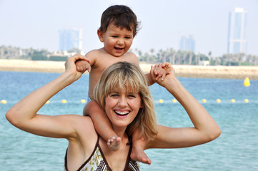 Fototapeta na wymiar Happy mother and son playing on the beach