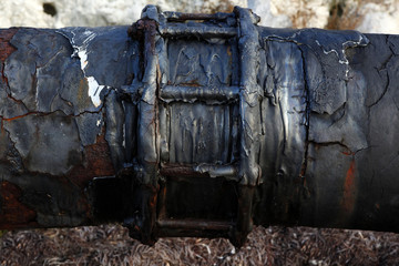 Weathered water pipe joint and crackeling asphalt coat