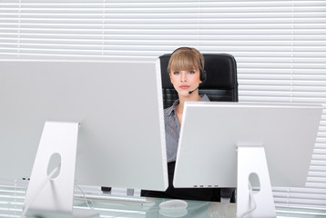 Young business woman in her office with head phones