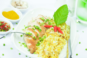 White plate with cury rice chicken fillet and basil
