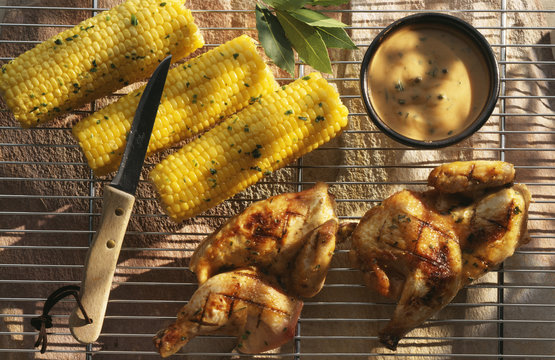 Demi-coquelets grill&eacute;s, &eacute;pis de ma&iuml;s grill&eacute;s et sauce au poivre vert
