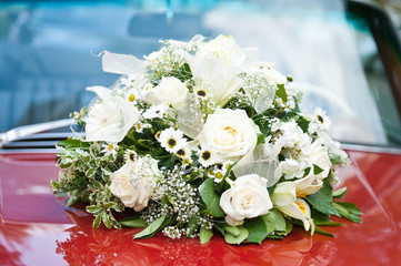weißer blumenstrauß auf brautwagen