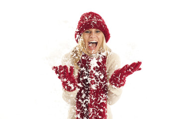 Young woman with red hat and scarf throwing snow