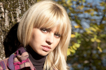 Naklejka premium girl against a tree and yellow leaves