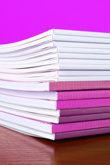 Pile of color magazines isolated on yellow background