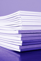 Pile of color magazines isolated on yellow background