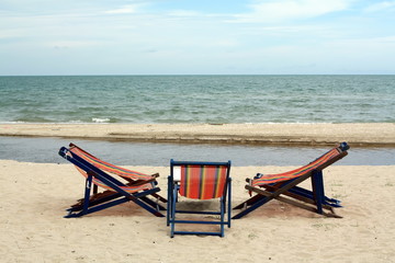 sun beach chairs on shore near sea