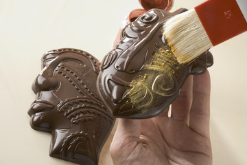 Badigeonner de colorant les chocolats en forme de masques de Papouasie et de Tanzanie