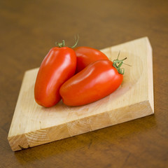 Tomates olivettes entières sur planche en bois