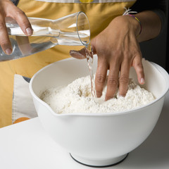 Ajouter l'eau à la farine pour la pâte 