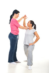 Fitness instructor assisting woman