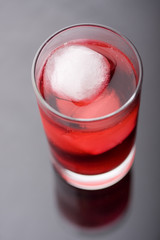 Glass of red liquid and ice