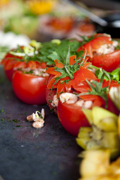 A cold buffet with the stuffed tomatoes in focus