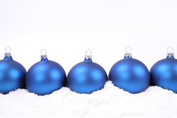 Blue matte christmas balls on snow, with space for your text