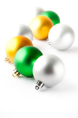 Green, gold and silver Christmas baubles on white