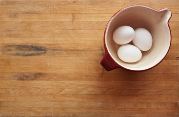 Bowl filled with eggs on a butcher block counter