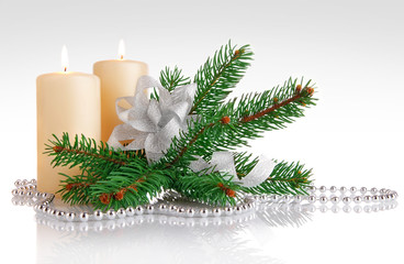 burning candle with branch firtree and silvery bow