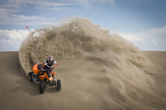 Quad rider in sand dunes roost