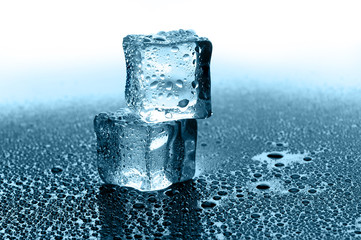 wet ice cubes on black glossy background