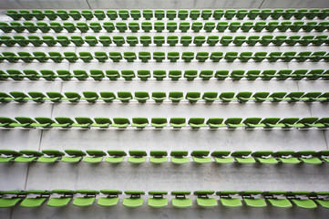 Fototapeta premium Rows of folded, green, plastic seats in empty stadium.