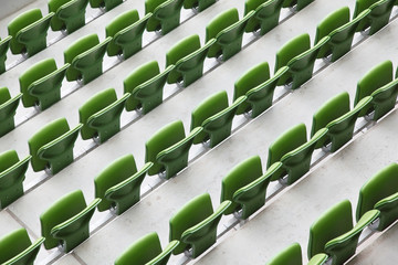 Naklejka premium Many rows of green, plastic, folding seats in empty stadium.