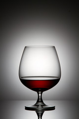 Glass of brandy over gray background