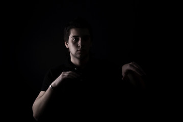 Naklejka premium portrait of a young man in darkness