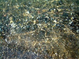 Background.Pebble on a beach in sea water