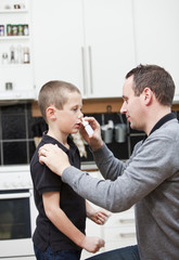 Father giving son Nose Drops