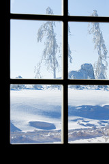 view of winter storm through paned window