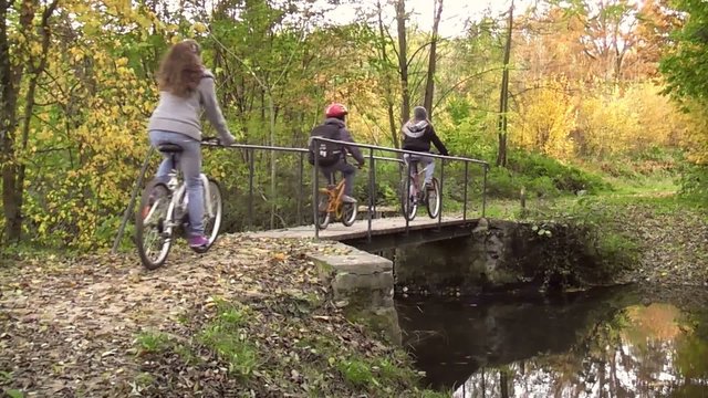 Trois enfants traversant un pont en vélo
