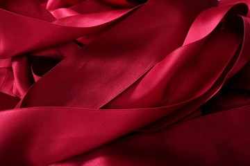 Red satin ribbons in a messy mess texture