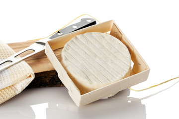 Camembert cheese in box and knife, isolated