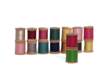 Stacked Spools of Colorful Thread on a White Background