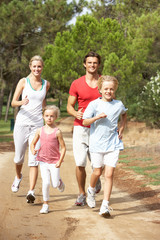 Naklejka na ściany i meble Family running on path in park