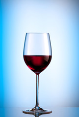 glass of red wine with a blue background