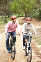 Couple riding bicycle in park