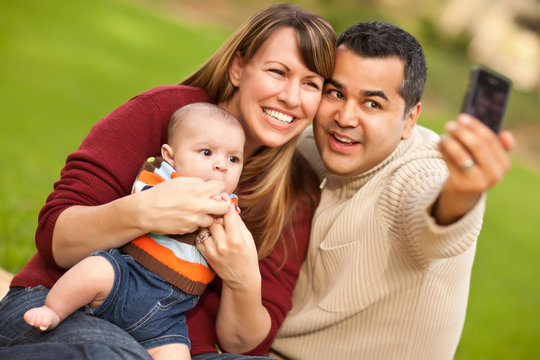 Happy Mixed Race Parents and Baby Boy Taking Self Portraits