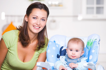 Happy mother with baby on kitchen