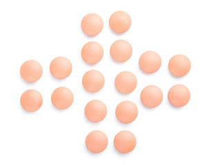 Orange pills cross close-up